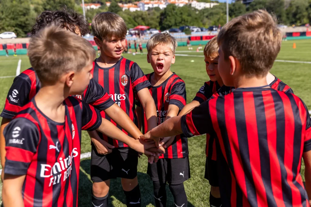 Young players putting their hands together in a team huddle before training